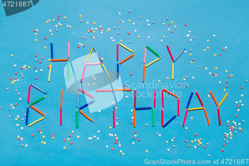 Image of words happy birthday made of candles on blue