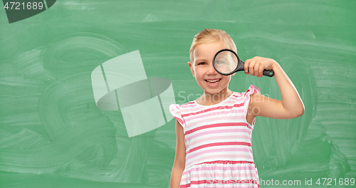 Image of girl looking through magnifying glass at school