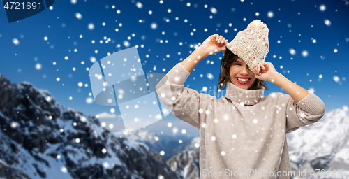 Image of young woman in knitted winter hat in mountains