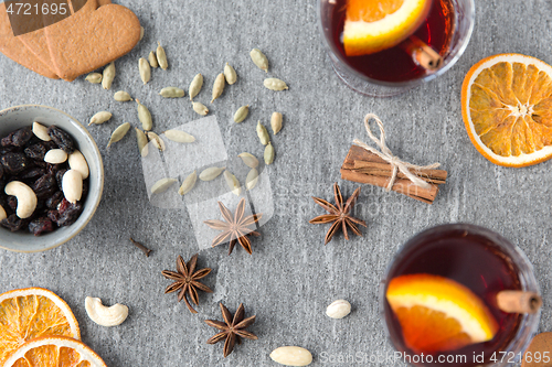 Image of hot mulled wine, orange slices, raisins and spices