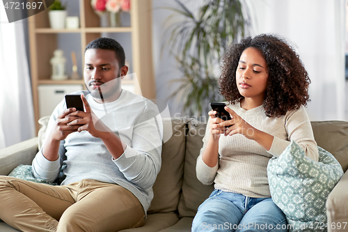 Image of african american couple with smartphone at home