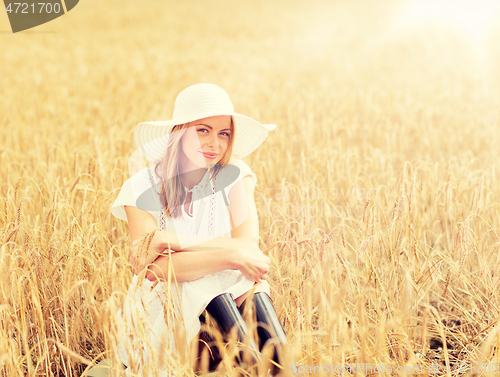 Image of happy young woman in sun hat on cereal field