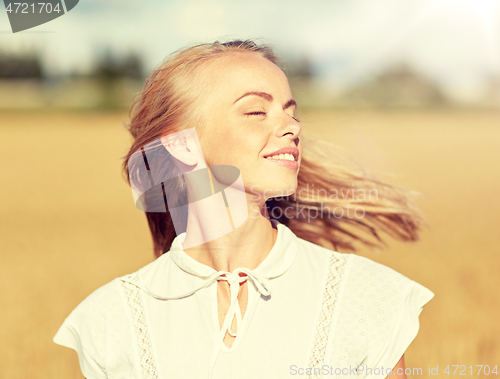 Image of smiling young woman in white on cereal field