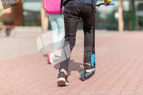 Image of school children with backpacks and scooters