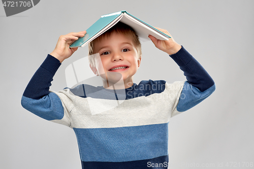 Image of little boy with roof of book on top of his head