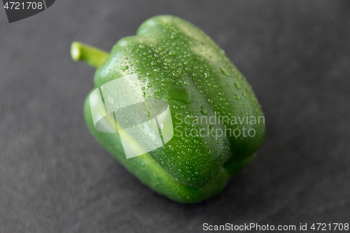 Image of close up of green pepper on slate stone background