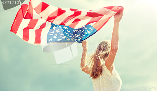 Image of happy young woman with american flag outdoors