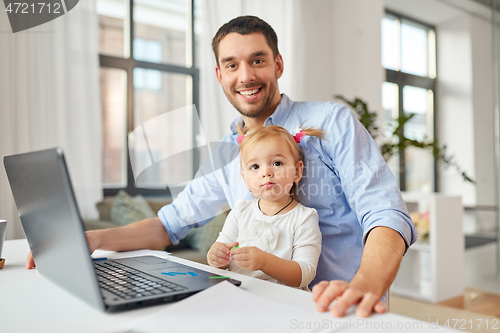 Image of working father with baby daughter at home office