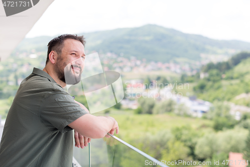 Image of man standing on a modern balcony