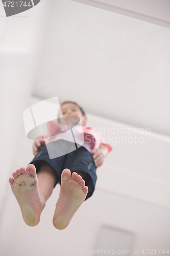 Image of little boy standing on transparent glass floor