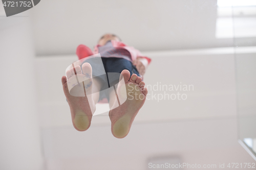 Image of little boy standing on transparent glass floor