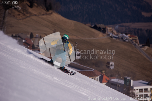 Image of snowboarder running down the slope and ride free style