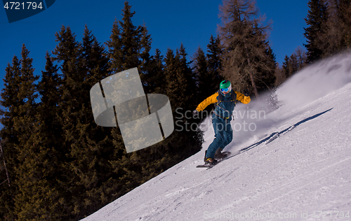 Image of snowboarder running down the slope and ride free style