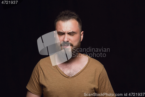 Image of Close up portrait of young man isolated on black studio background