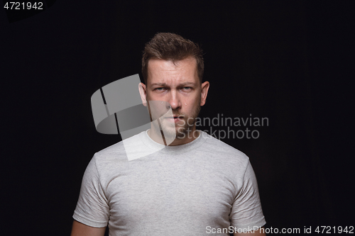 Image of Close up portrait of young man isolated on black studio background