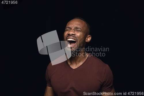 Image of Close up portrait of young man isolated on black studio background