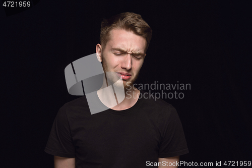 Image of Close up portrait of young man isolated on black studio background