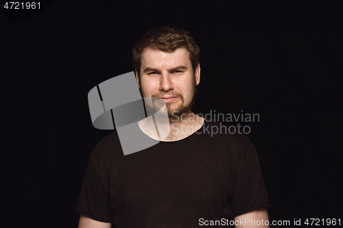 Image of Close up portrait of young man isolated on black studio background