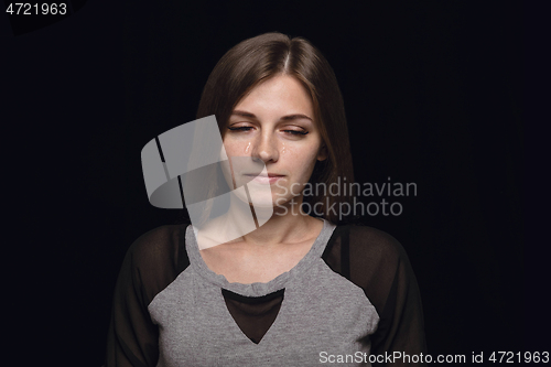 Image of Close up portrait of young woman isolated on black studio background