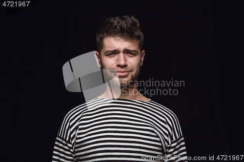 Image of Close up portrait of young man isolated on black studio background