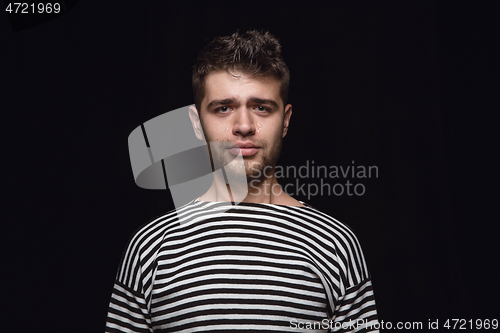 Image of Close up portrait of young man isolated on black studio background