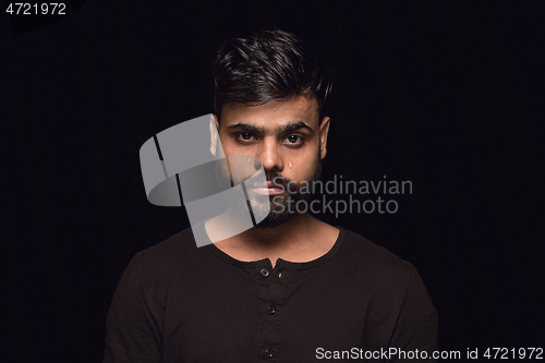 Image of Close up portrait of young man isolated on black studio background