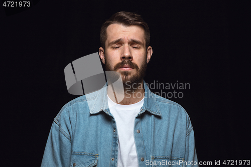 Image of Close up portrait of young man isolated on black studio background