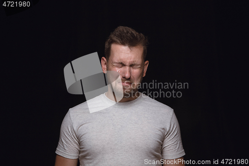 Image of Close up portrait of young man isolated on black studio background