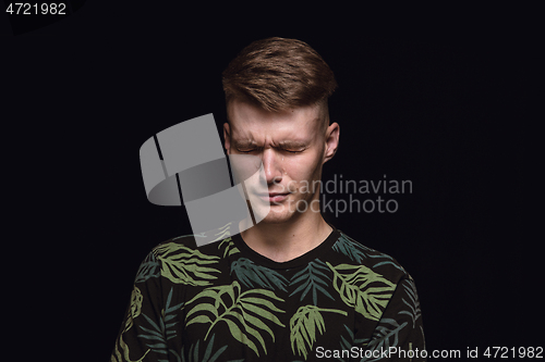 Image of Close up portrait of young man isolated on black studio background