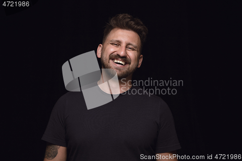 Image of Close up portrait of young man isolated on black studio background