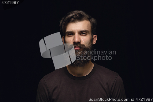 Image of Close up portrait of young man isolated on black studio background