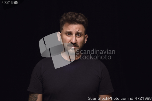 Image of Close up portrait of young man isolated on black studio background