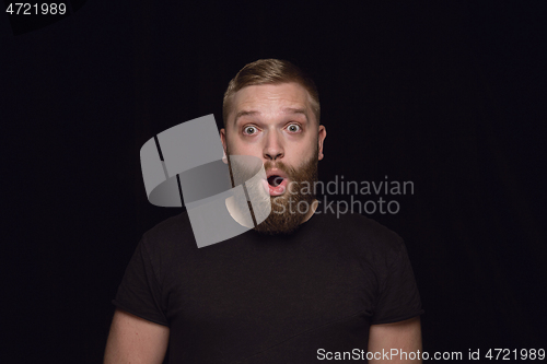 Image of Close up portrait of young man isolated on black studio background