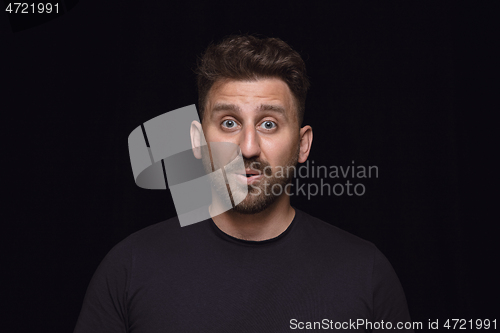 Image of Close up portrait of young man isolated on black studio background