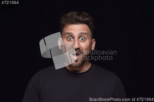 Image of Close up portrait of young man isolated on black studio background