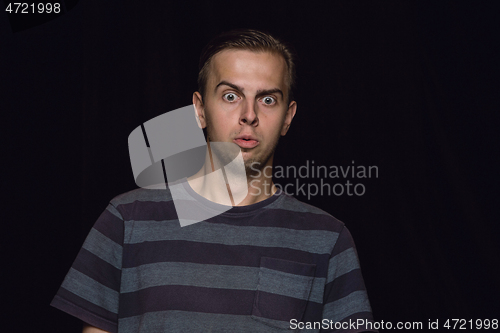 Image of Close up portrait of young man isolated on black studio background