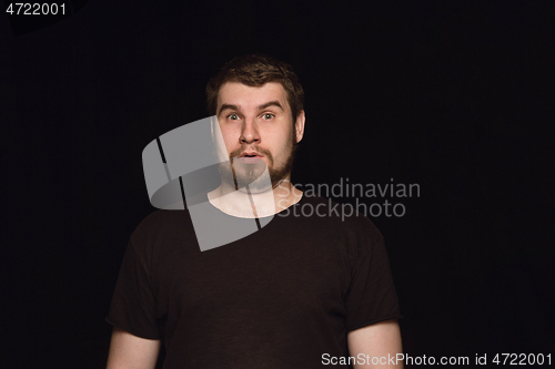 Image of Close up portrait of young man isolated on black studio background