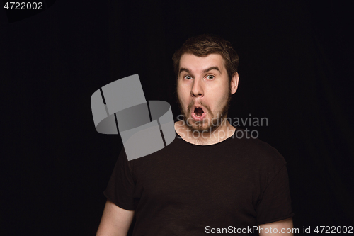 Image of Close up portrait of young man isolated on black studio background