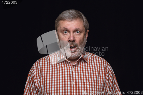 Image of Close up portrait of senior man isolated on black studio background