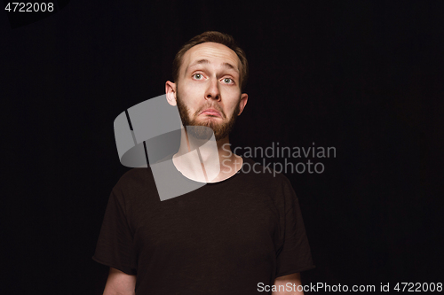 Image of Close up portrait of young man isolated on black studio background