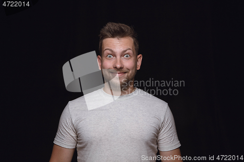 Image of Close up portrait of young man isolated on black studio background