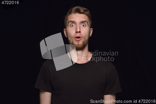 Image of Close up portrait of young man isolated on black studio background