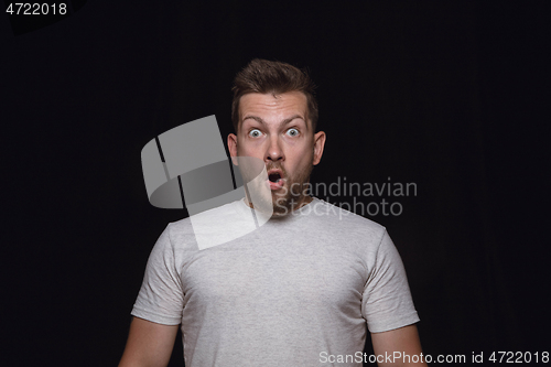 Image of Close up portrait of young man isolated on black studio background