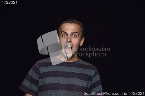 Image of Close up portrait of young man isolated on black studio background