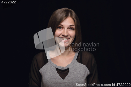 Image of Close up portrait of young woman isolated on black studio background