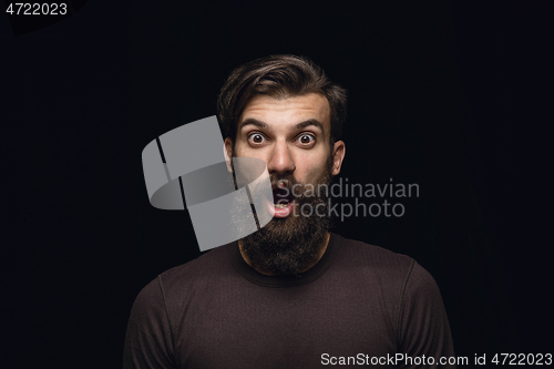 Image of Close up portrait of young man isolated on black studio background