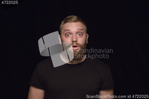 Image of Close up portrait of young man isolated on black studio background