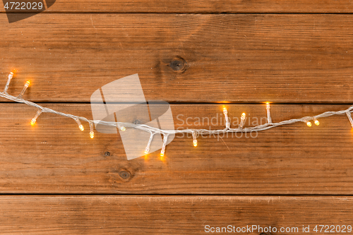 Image of christmas garland lights on wooden background