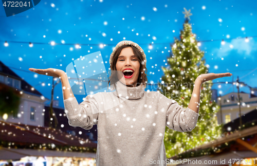 Image of happy woman in hat at christmas market