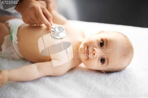 Image of doctor with stethoscope listening to baby patient